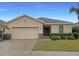 Tan one-story house with a two-car garage and landscaped lawn at 562 Vista Ridge Dr, Ruskin, FL 33570