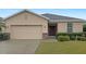 Tan one-story house with a two-car garage and landscaped lawn at 562 Vista Ridge Dr, Ruskin, FL 33570