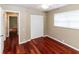 Bedroom with hardwood floors, neutral walls, and louvered doors at 3534 Player Dr, New Port Richey, FL 34655