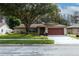 Single-story house with red garage door and well-maintained lawn at 3534 Player Dr, New Port Richey, FL 34655