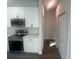 Modern kitchen with white cabinets, stainless steel appliances and a hallway at 1401 Newton St, Port Charlotte, FL 33952