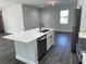 Modern kitchen island with white cabinets, quartz countertop & stainless steel dishwasher at 1401 Newton St, Port Charlotte, FL 33952