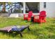 Relaxing backyard with red Adirondack chairs and cornhole game at 2917 Palm Dr, Punta Gorda, FL 33950