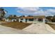 Cute one-story home with a light gray exterior, landscaping, and a driveway at 4215 Pecos Dr, New Port Richey, FL 34653