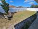 A backyard with a white fence, trees, fire pit, and patio furniture at 2022 Peaceful Palm St, Ruskin, FL 33570