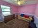 A bedroom with pink and purple walls, a sofa, and a dresser at 2022 Peaceful Palm St, Ruskin, FL 33570