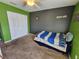 Bedroom featuring grey and green walls, carpet flooring, and white closet doors at 2022 Peaceful Palm St, Ruskin, FL 33570