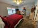 Bedroom with a red bedspread, ceiling fan, and wood dresser at 2022 Peaceful Palm St, Ruskin, FL 33570