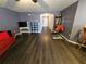 View down hallway with dark hardwood floors and red couch at 2022 Peaceful Palm St, Ruskin, FL 33570