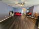 Spacious living room featuring hardwood floors, a ceiling fan, and large windows at 2022 Peaceful Palm St, Ruskin, FL 33570