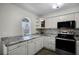 Updated kitchen featuring granite countertops and white cabinets at 13910 Fullerton Dr, Tampa, FL 33625