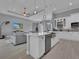 Open concept kitchen with island, white cabinets, and stainless steel appliances at 143 Long Meadow Ln, Rotonda West, FL 33947