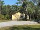 Detached garage with gravel driveway and surrounding trees at 7027 Hawkins Rd, Sarasota, FL 34241