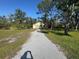 Detached garage with gravel driveway and lush green lawn at 7027 Hawkins Rd, Sarasota, FL 34241