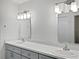 Double vanity bathroom with modern lighting and gray cabinets at 2321 E Del Webb Blvd, Sun City Center, FL 33573