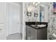 Stylish bathroom with gray vanity, black countertop, and unique wallpaper at 3135 Great Banyan Way, Wesley Chapel, FL 33543