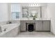 Spa-like bathroom featuring a soaking tub and gray double vanity at 3135 Great Banyan Way, Wesley Chapel, FL 33543