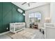 Charming Bedroom with green accent wall and crib at 3135 Great Banyan Way, Wesley Chapel, FL 33543