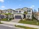 Two-story house with gray siding, stone accents, and a 3-car garage at 3135 Great Banyan Way, Wesley Chapel, FL 33543