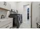 Clean laundry room features a sink, shelving and leads to a wine cellar at 3135 Great Banyan Way, Wesley Chapel, FL 33543