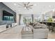 Open-concept living room with gray sectional sofa and kitchen view at 3135 Great Banyan Way, Wesley Chapel, FL 33543