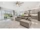 Open living room featuring a gray sectional sofa and access to the kitchen at 3135 Great Banyan Way, Wesley Chapel, FL 33543