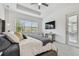 Main bedroom with sliding door access to patio and large TV at 3135 Great Banyan Way, Wesley Chapel, FL 33543