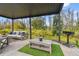 Relaxing pergola-covered patio with seating area and fire pit, overlooking a natural landscape at 3135 Great Banyan Way, Wesley Chapel, FL 33543