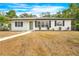 Newly renovated home with white exterior, landscaping, and walkway at 6154 Ashland Dr, Spring Hill, FL 34606