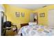 Bedroom with a queen-size bed and yellow walls at 18004 Tarrington Pl, Hudson, FL 34667