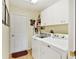 Laundry room with washer, dryer, and cabinets at 18004 Tarrington Pl, Hudson, FL 34667