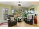 Relaxing sunroom with large windows, comfy seating, and wood floor at 18004 Tarrington Pl, Hudson, FL 34667