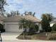 Tan single-story house with a two-car garage and palm trees at 3375 Osprey Ln, Port Charlotte, FL 33953
