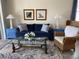 Living room with blue sofa, wicker chair, and nautical artwork at 3375 Osprey Ln, Port Charlotte, FL 33953