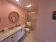 Bathroom with a granite vanity, a walk-in shower, and a pink color scheme at 7580 Camminare Dr, Sarasota, FL 34238