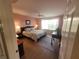 Main bedroom with a queen bed, hardwood floors, and ensuite access at 7580 Camminare Dr, Sarasota, FL 34238
