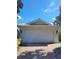 Front view of a house with a white garage door and brick driveway at 7580 Camminare Dr, Sarasota, FL 34238