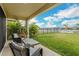 Covered patio overlooking a fenced-in backyard with a lake view at 13015 Homestead Ln, Parrish, FL 34219