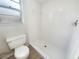 All-white tiled bathroom featuring a tiled shower and toilet at 14315 Knoll Ridge Dr, Tampa, FL 33625