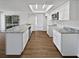 Well-lit kitchen featuring white cabinetry, stone counters, stainless appliances, and modern lighting at 14315 Knoll Ridge Dr, Tampa, FL 33625