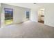 Spacious living room features neutral carpet, white walls and view of the back yard at 14315 Knoll Ridge Dr, Tampa, FL 33625