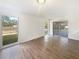 Bright living room with wood-look flooring, neutral walls, sliding door access, and natural light at 14315 Knoll Ridge Dr, Tampa, FL 33625