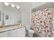 Bathroom with granite countertop, shower, and floral curtain at 7092 Baypine Ln, Englewood, FL 34224