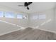 Bedroom with gray walls, ceiling fan, and wood-look floors at 7092 Baypine Ln, Englewood, FL 34224