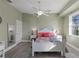 Bedroom with white bed frame, colorful bedding, and ceiling fan at 7092 Baypine Ln, Englewood, FL 34224