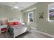 Bright bedroom with a white bed frame, colorful bedding, and ceiling fan at 7092 Baypine Ln, Englewood, FL 34224