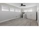 Bedroom with gray walls, ceiling fan, and wood-look floors at 7092 Baypine Ln, Englewood, FL 34224
