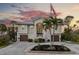 Two-story house with attached garage and palm trees in the front yard at 7092 Baypine Ln, Englewood, FL 34224