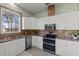 Modern kitchen with white cabinets, stainless steel appliances, and granite countertops at 7092 Baypine Ln, Englewood, FL 34224
