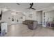 Bright living room with hardwood floors, sectional sofa, and views to the kitchen and entry at 7092 Baypine Ln, Englewood, FL 34224
